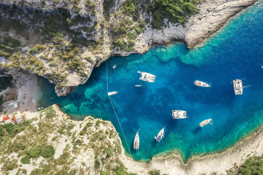 Dronebilde av Stiniva Covert Cove-stranden i Adriaterhavet på øya Vis i Kroatia om sommeren.