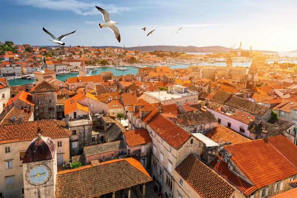 View at town Trogir, old touristic place in Croatia Europe with seagull's flying over city. Trogir town coastal view. Magnificent Trogir, Croatia. Sunny old Venetian town, Dalmatian Coast in Croatia.
